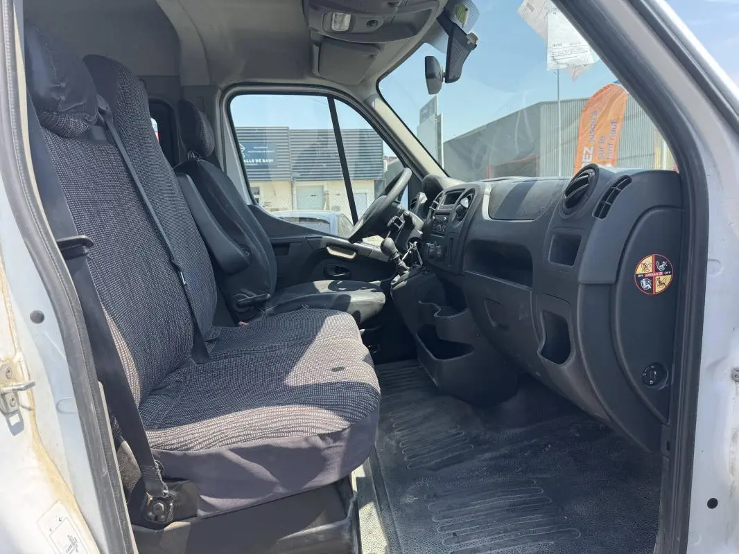 Vue intérieure côté conducteur du Renault Master blanc 2019, montrant les sièges avant et le tableau de bord noir.