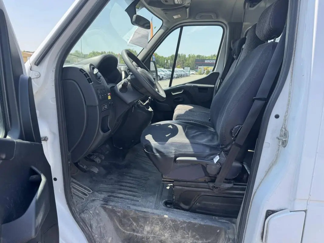 Vue intérieure côté conducteur du Renault Master blanc 2019, montrant les sièges avant et le tableau de bord simple.