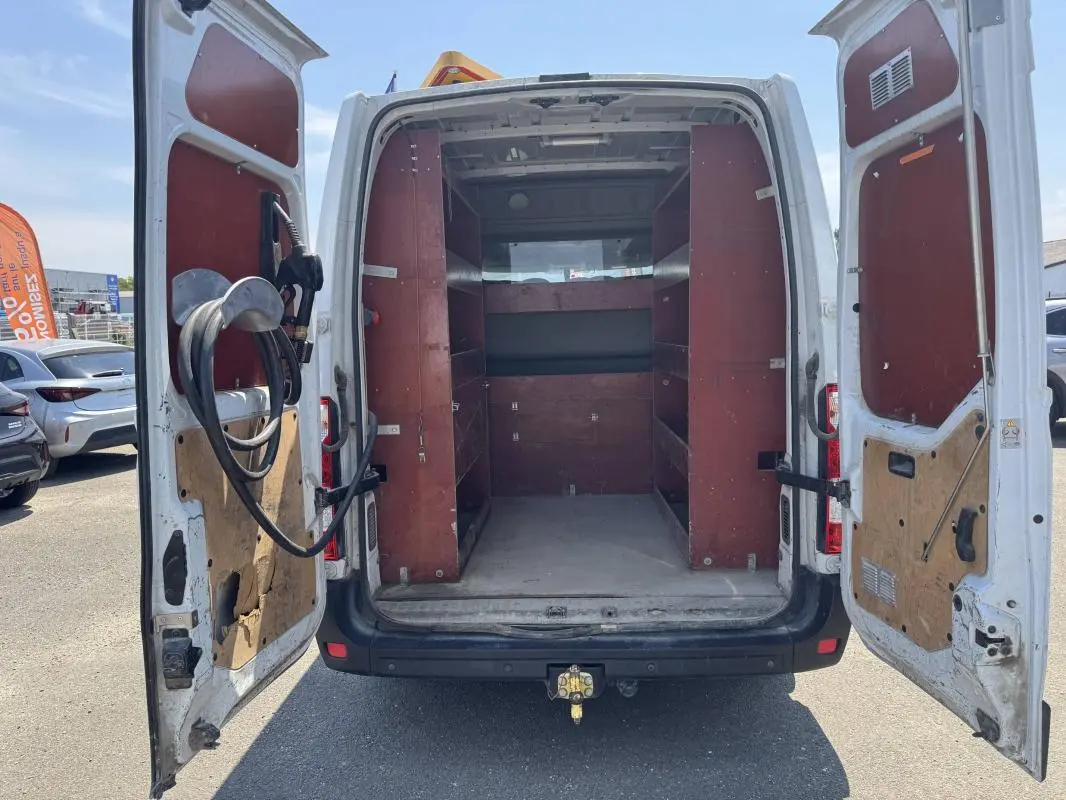 Vue arrière ouverte du Renault Master blanc 2019 avec aménagements en bois et étagères dans la zone de chargement.