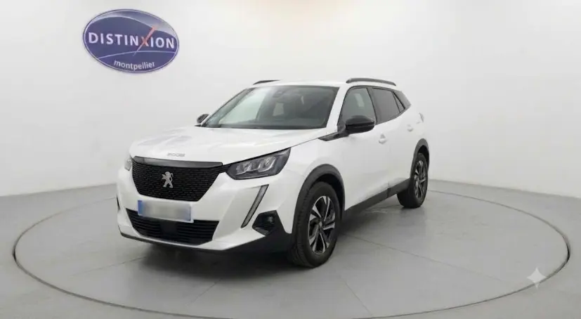 Peugeot 2008 blanc en 3/4 avant droit, SUV compact avec calandre noire et jantes alliage distinctives.