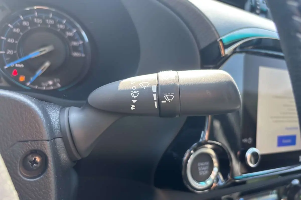 Gros plan sur la commande d’essuie-glace à gauche du volant cuir dans le Toyota Hilux 4x4 gris atlas 2026.