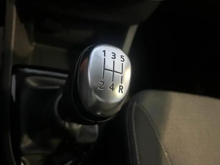 Le levier de vitesses manuel en aluminium de la Renault Clio IV gris argent, vu en gros plan depuis l'intérieur côté conducteur.