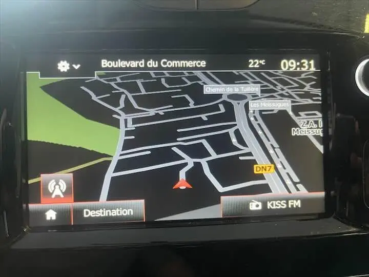 Écran tactile de navigation GPS de la Renault Clio IV gris argent, affichant une carte routière et la radio KISS FM.
