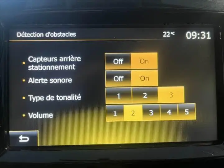 Écran tactile intérieur de la Renault Clio IV gris argent montrant les réglages de détection d'obstacles et alertes sonores.