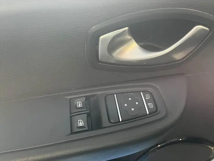 Détail de la commande des vitres et du rétroviseur côté gauche d'une Renault Clio IV gris argent, intérieur noir.