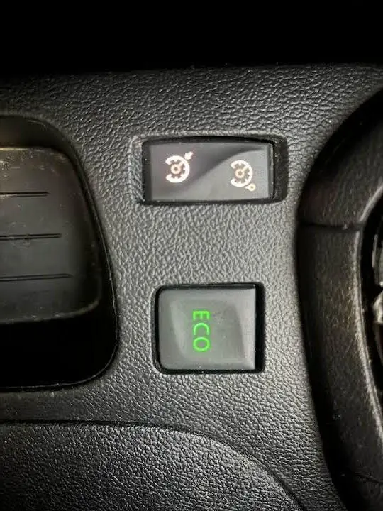 Boutons de commande du mode ECO et régulateur de vitesse sur la console intérieure d'une Renault Clio IV gris argent.