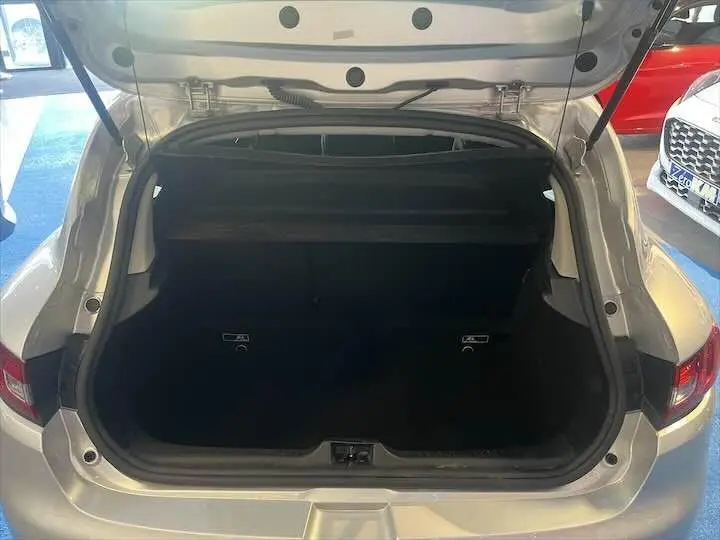 Coffre ouvert d'une Renault Clio IV gris argent vue de l'arrière, montrant l'espace de chargement vide.