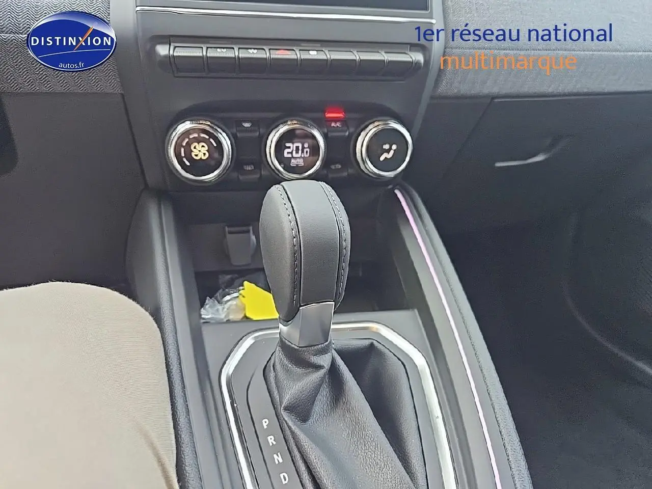 Le levier de boîte manuelle noir et la console centrale avec commandes de climatisation d'une Renault Clio V gris schiste.