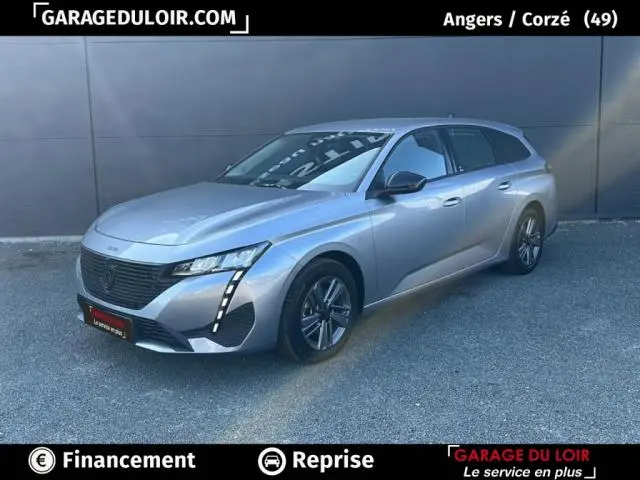 Peugeot 308 gris clair vue 3/4 avant droit, avec feux LED verticaux distinctifs et calandre noire.