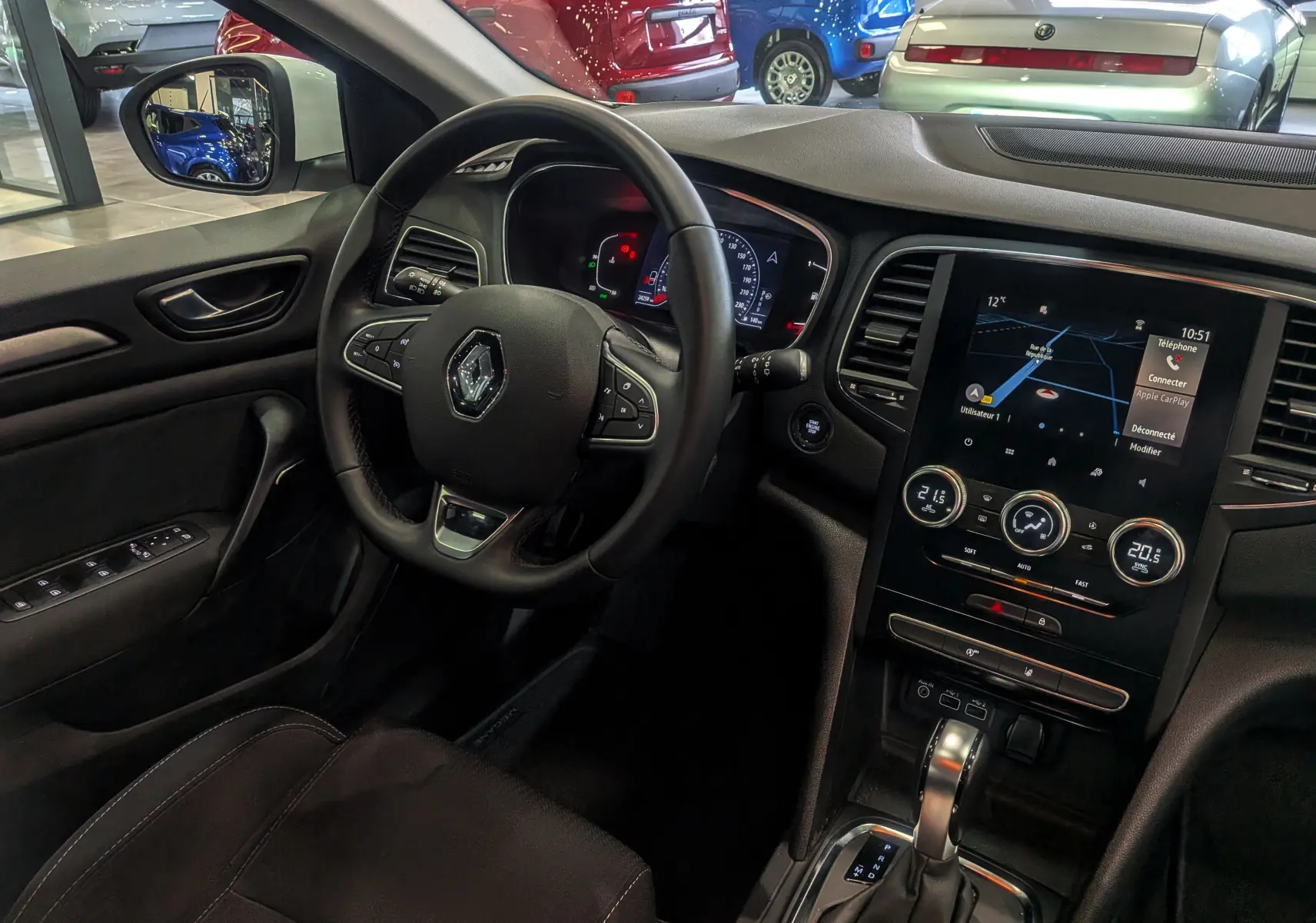 Vue intérieure côté conducteur de la Renault Mégane IV Berline 2021 avec tableau de bord numérique et écran tactile central.