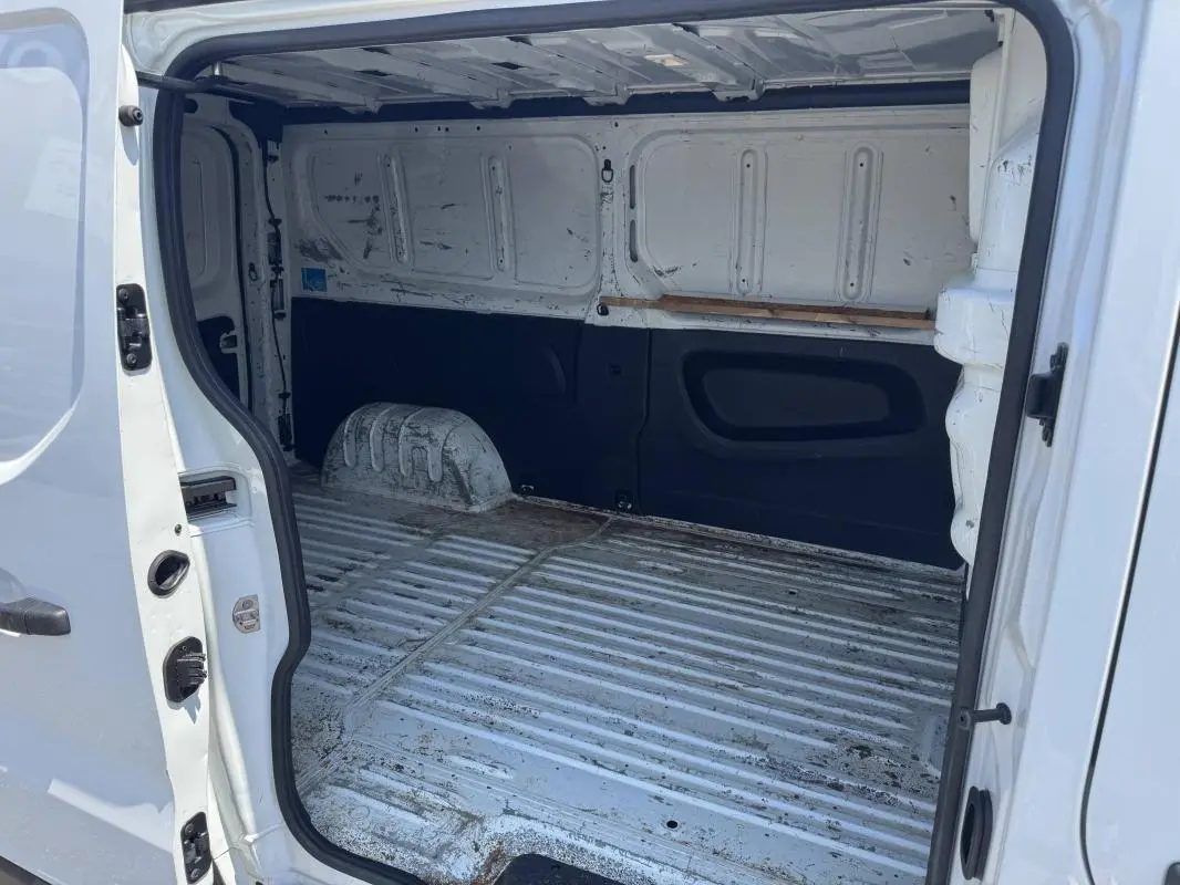 Vue intérieure arrière du Renault Trafic Fourgon blanc 2019, montrant l'espace de chargement vide et usé.