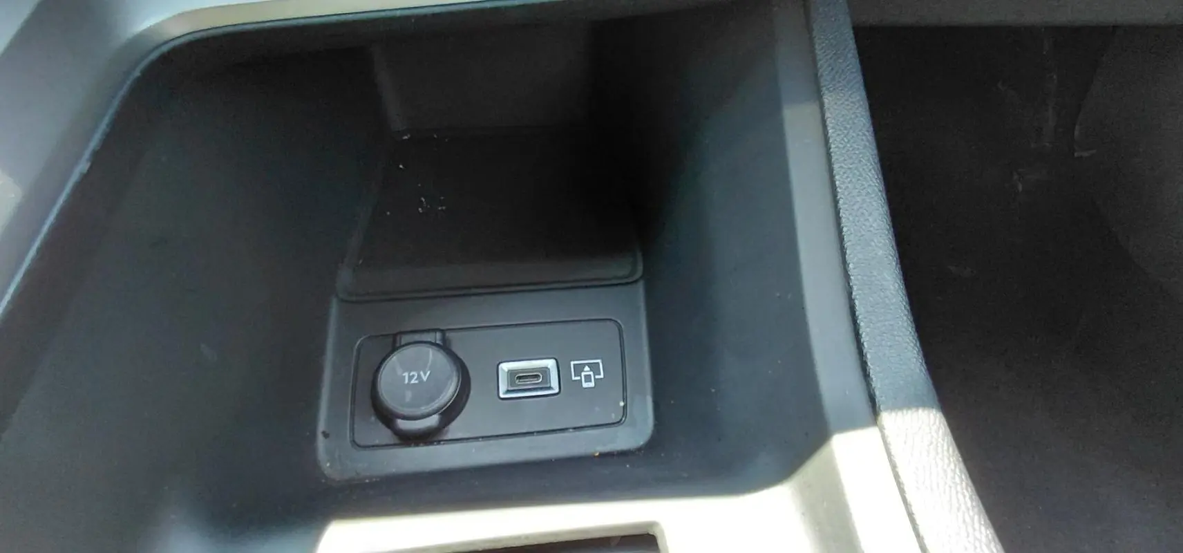 Prise 12V et port USB dans le compartiment central avant d’une Peugeot 308 SW gris, version Hybrid 145 e-DCS6 Allure.