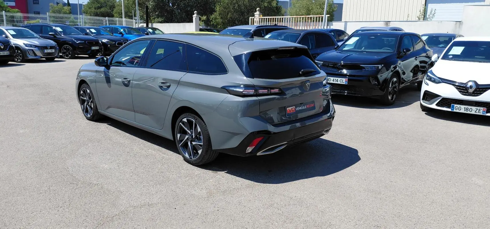 Peugeot 308 SW Hybrid gris vue 3/4 arrière droit, avec jantes alliage 17 pouces et vitres teintées.