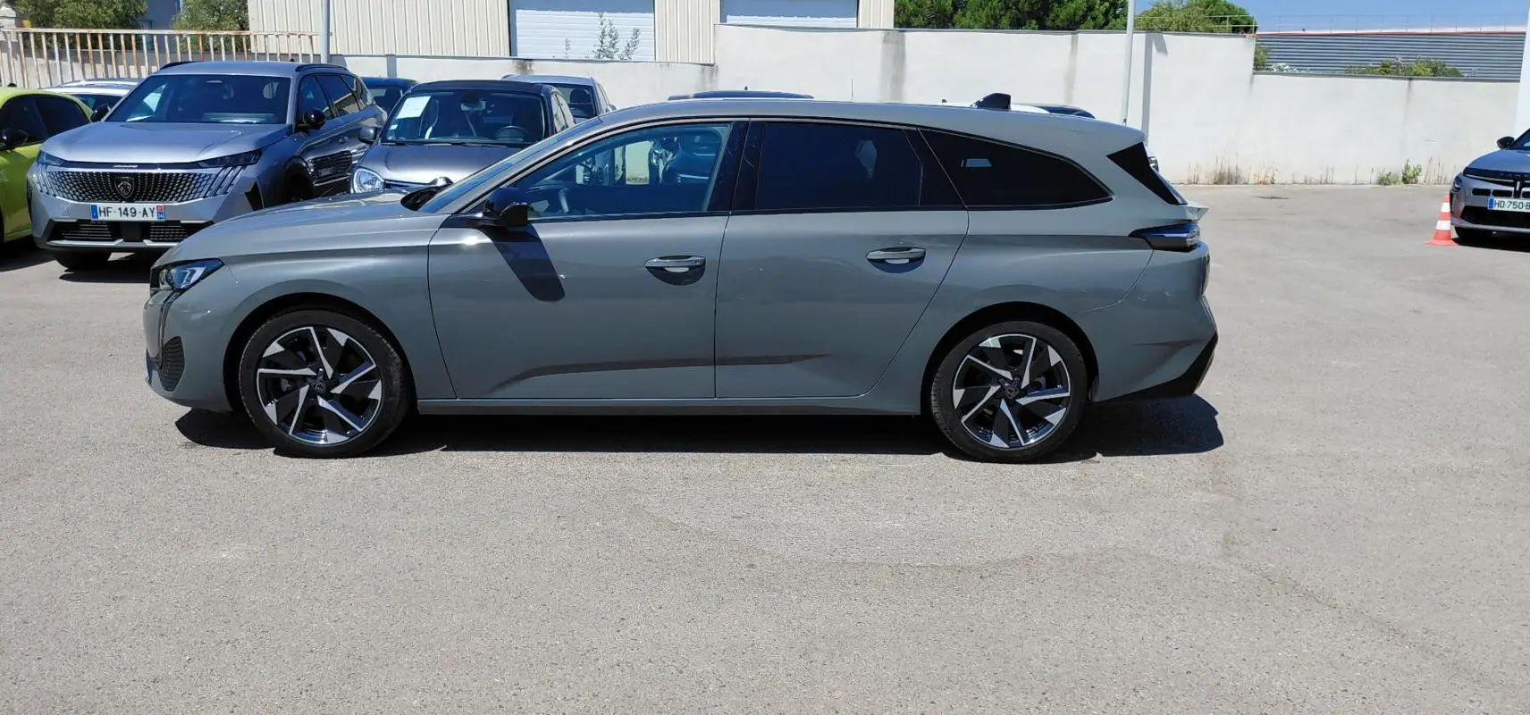 Peugeot 308 SW Hybrid gris vue de profil côté gauche, avec jantes alliage 17 pouces et vitres teintées.