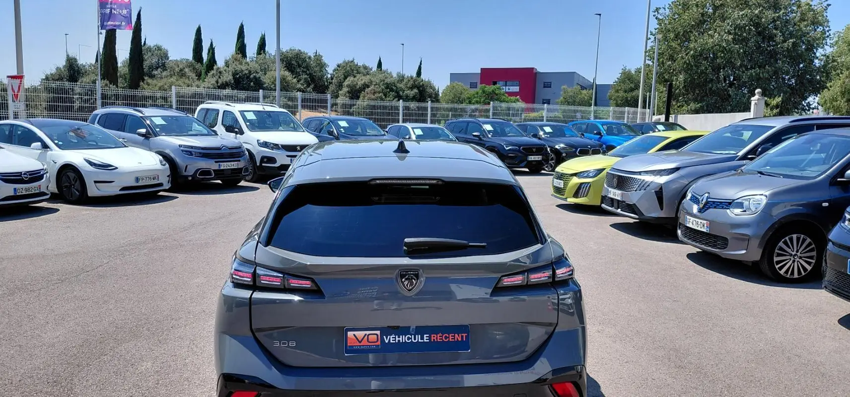 Vue arrière d'une Peugeot 308 SW Hybrid 145 gris métallisé, avec feux LED distinctifs et jantes alliage 17 pouces.