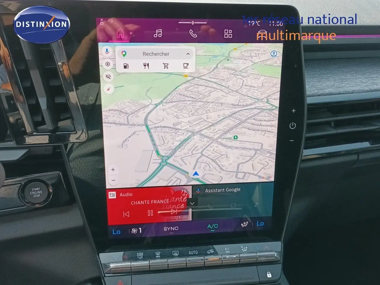 Vue rapprochée de l’écran tactile central du Renault Austral 2025 gris schiste métal avec navigation GPS et commandes climatisation.