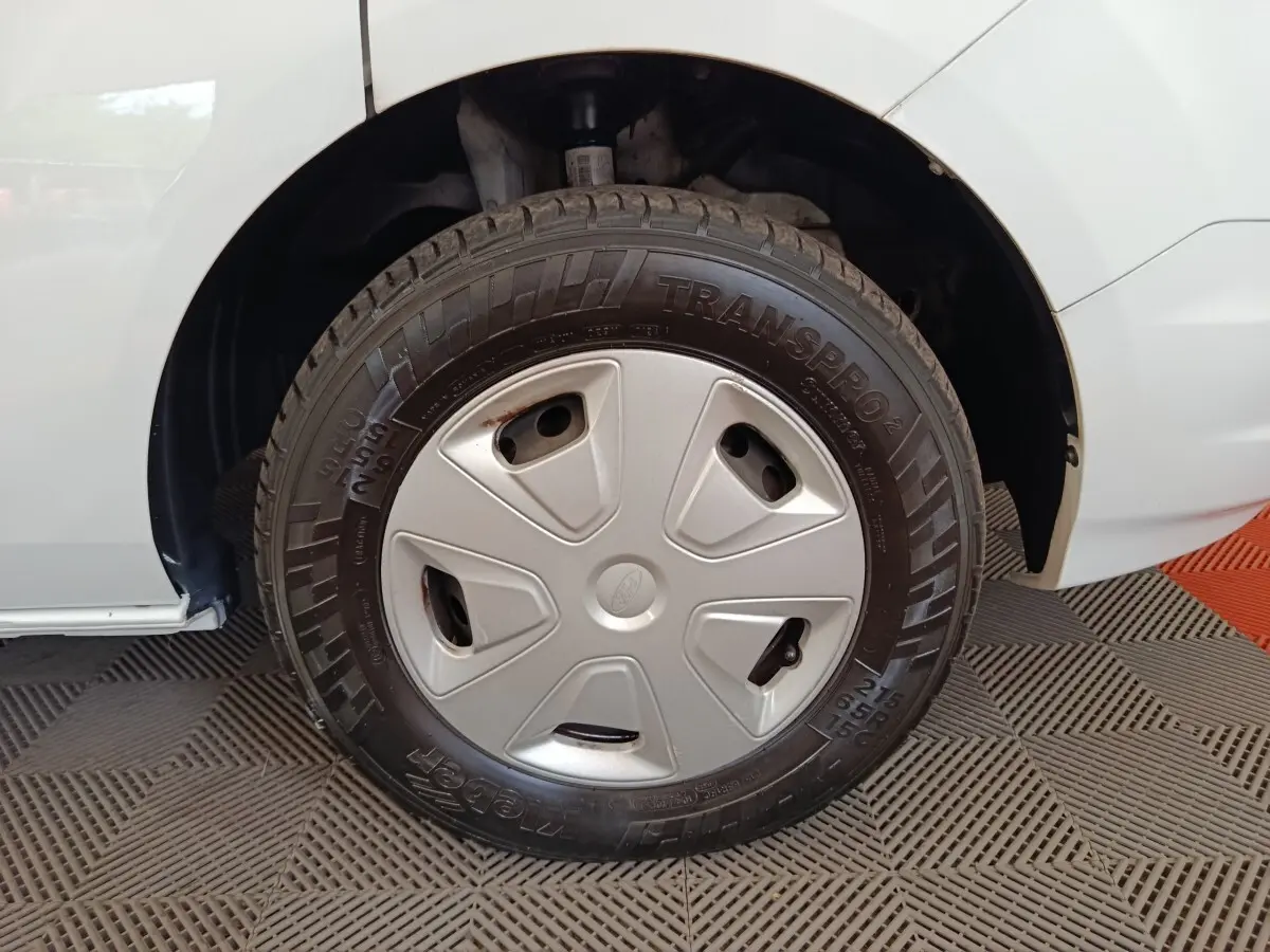 Gros plan sur la roue avant droite du Ford Transit Custom blanc, avec enjoliveur gris et pneu Michelin Transpro.