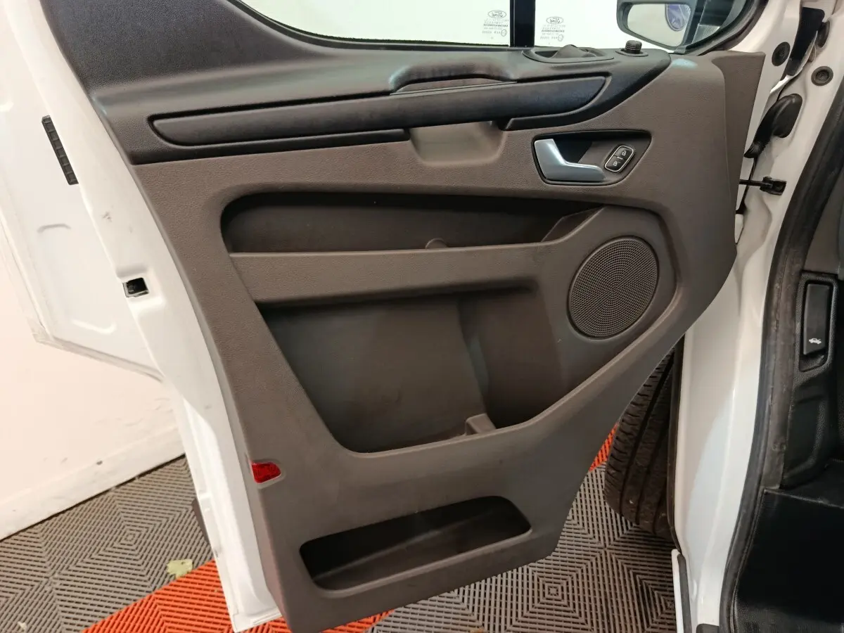 Vue intérieure de la porte avant droite blanche du Ford Transit Custom Fourgon, avec panneau noir et commande de vitre.