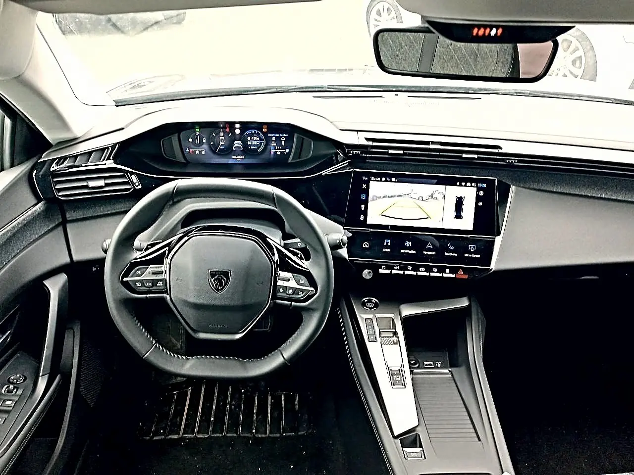 Intérieur Peugeot 408 Hybrid 145 allure e-dcs6 2024, vue tableau de bord avec volant cuir et écran tactile central allumé.