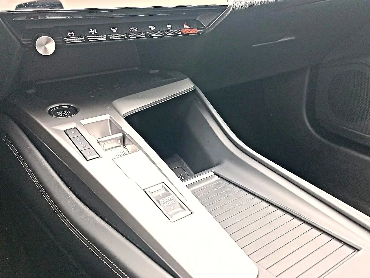 Vue rapprochée de la console centrale grise du Peugeot 408 Hybrid 145 allure 2024 avec boutons de démarrage et mode de conduite.