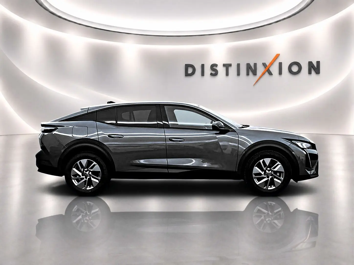 Profil droit du Peugeot 408 Hybrid 145 allure gris sellenium e avec jantes alu et toit noir dans un studio lumineux.