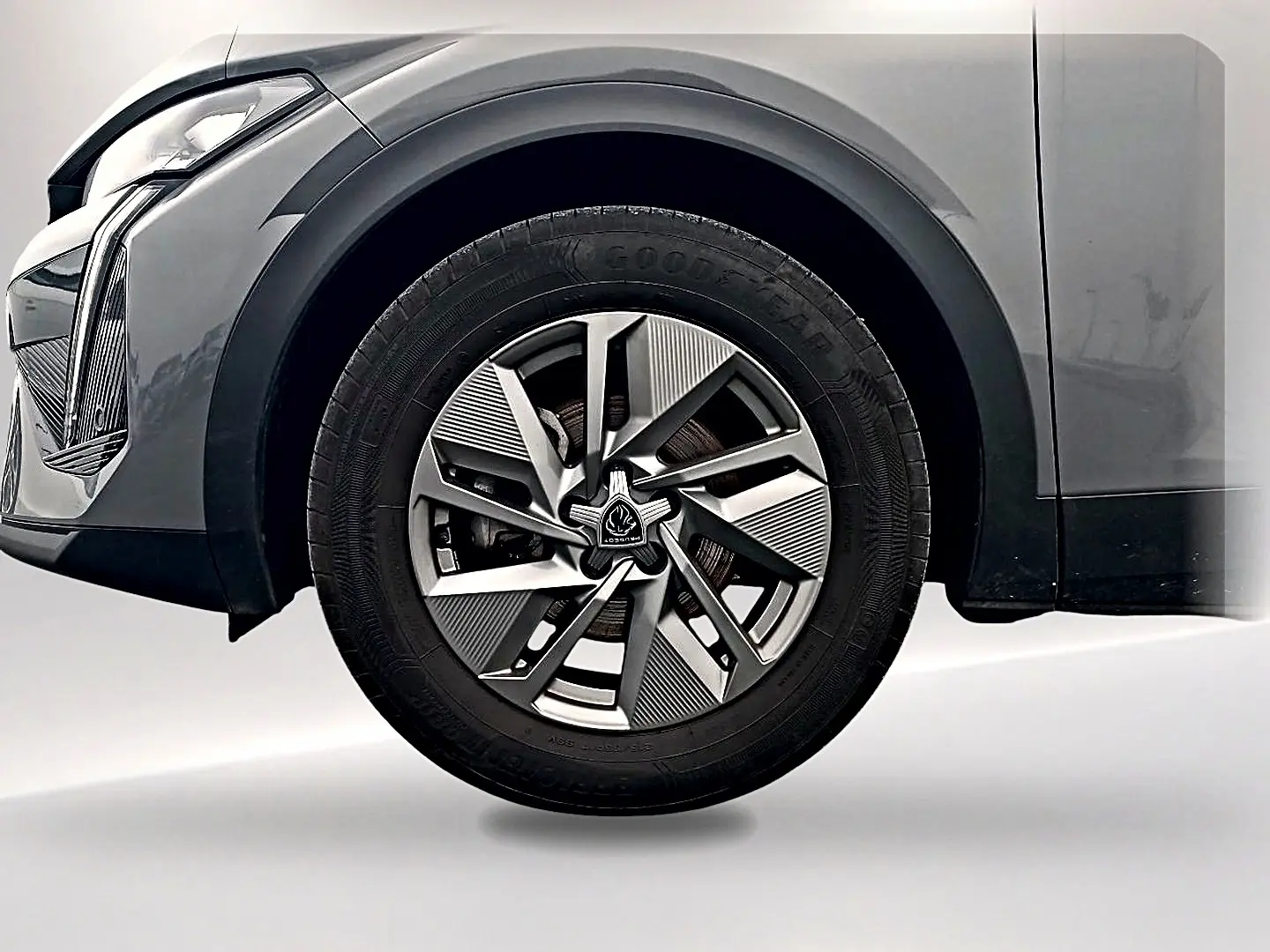 Gros plan sur la roue avant gauche de la Peugeot 408 Hybrid 145 allure gris sélénite avec jante alu au design moderne.