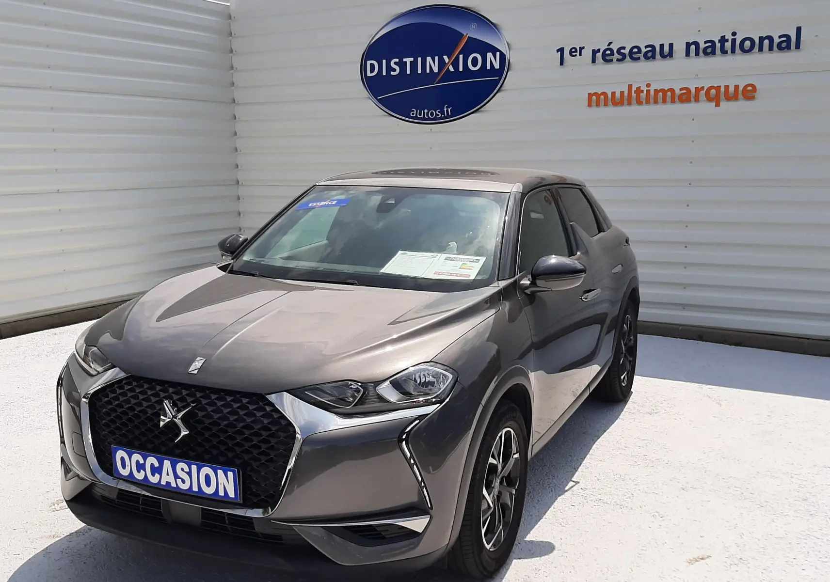 DS3 Crossback gris platinium métal en 3/4 avant droit, avec calandre distinctive et jantes bi-ton visibles.