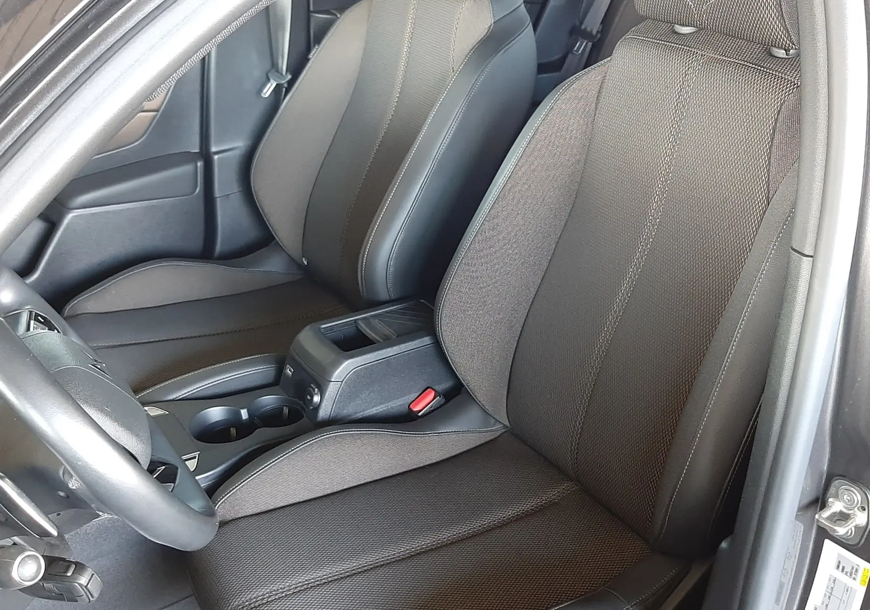 Vue intérieure côté conducteur du DS3 Crossback 2020 avec sièges en tissu noir et cuir, console centrale visible.