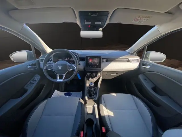 Intérieur avant de la Renault Clio V gris Rafale, volant textile, écran tactile Easy Link 7'' et boîte manuelle visible.