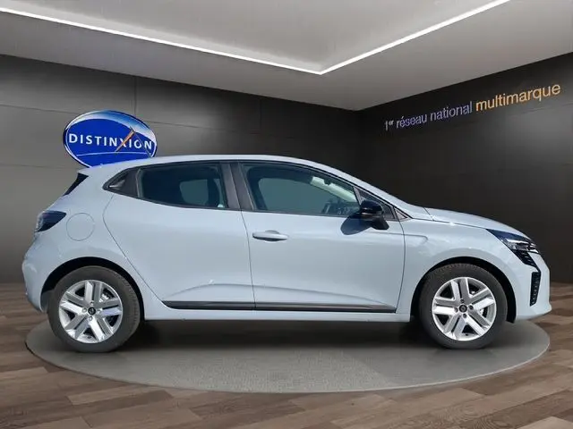 Profil droit d'une Renault Clio V blanche en intérieur avec jantes alliage et vitres teintées.