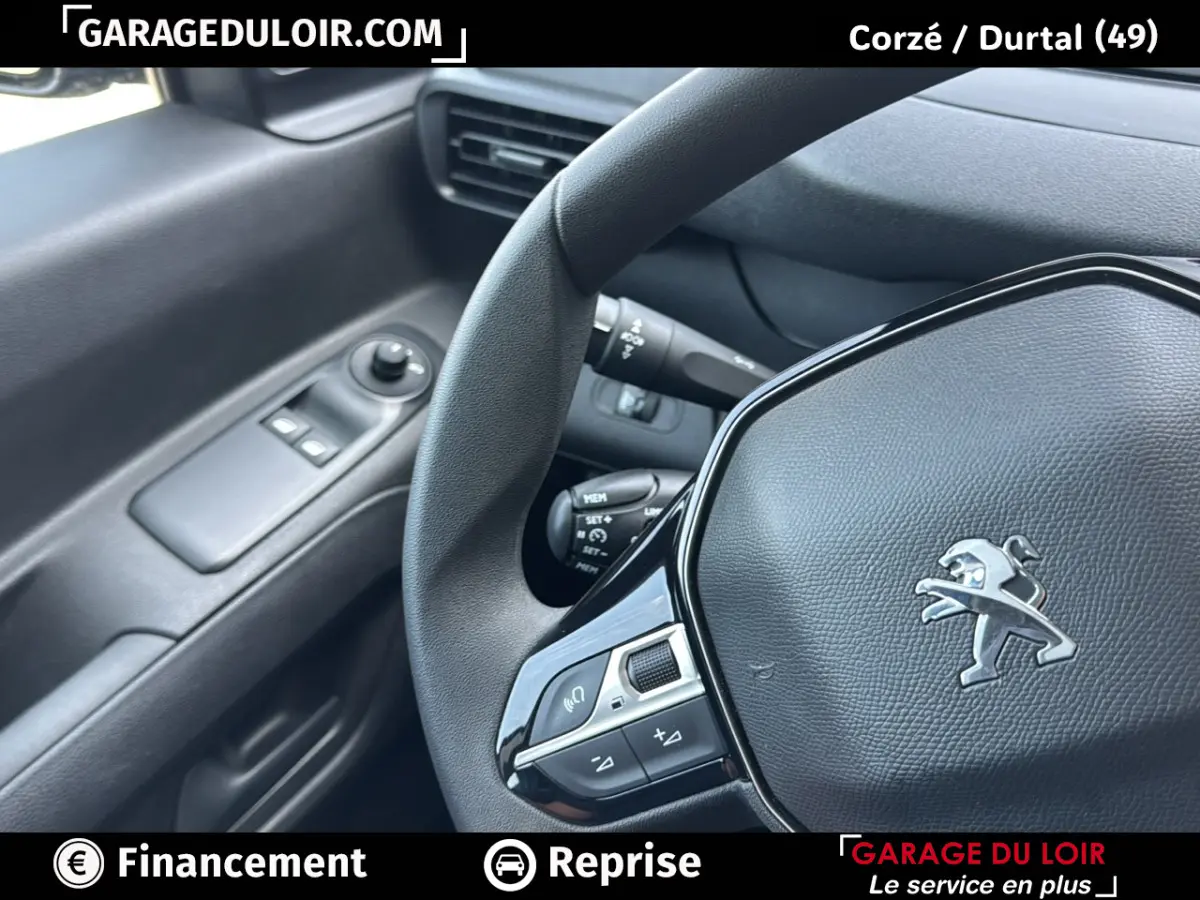 Vue rapprochée de l’intérieur du Peugeot Rifter 2024, volant cuir avec logo lion et commandes intégrées côté gauche.