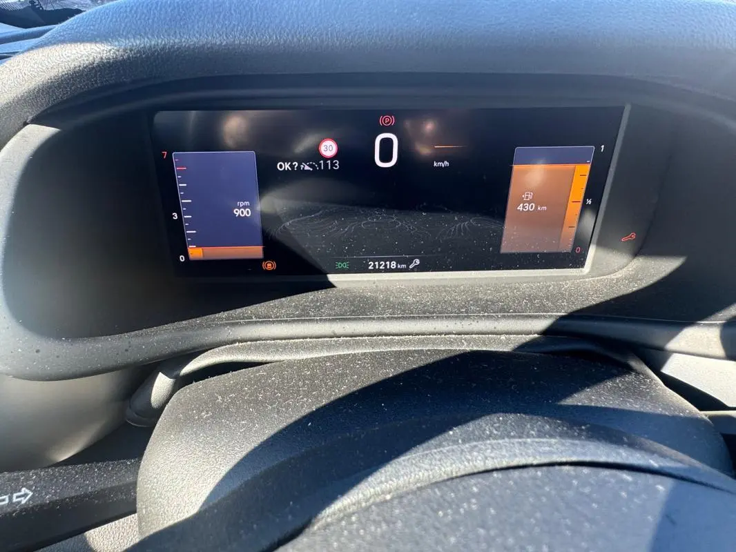 Tableau de bord numérique du Jeep Avenger 2025, affichage central avec compte-tours et autonomie, vue frontale intérieure.