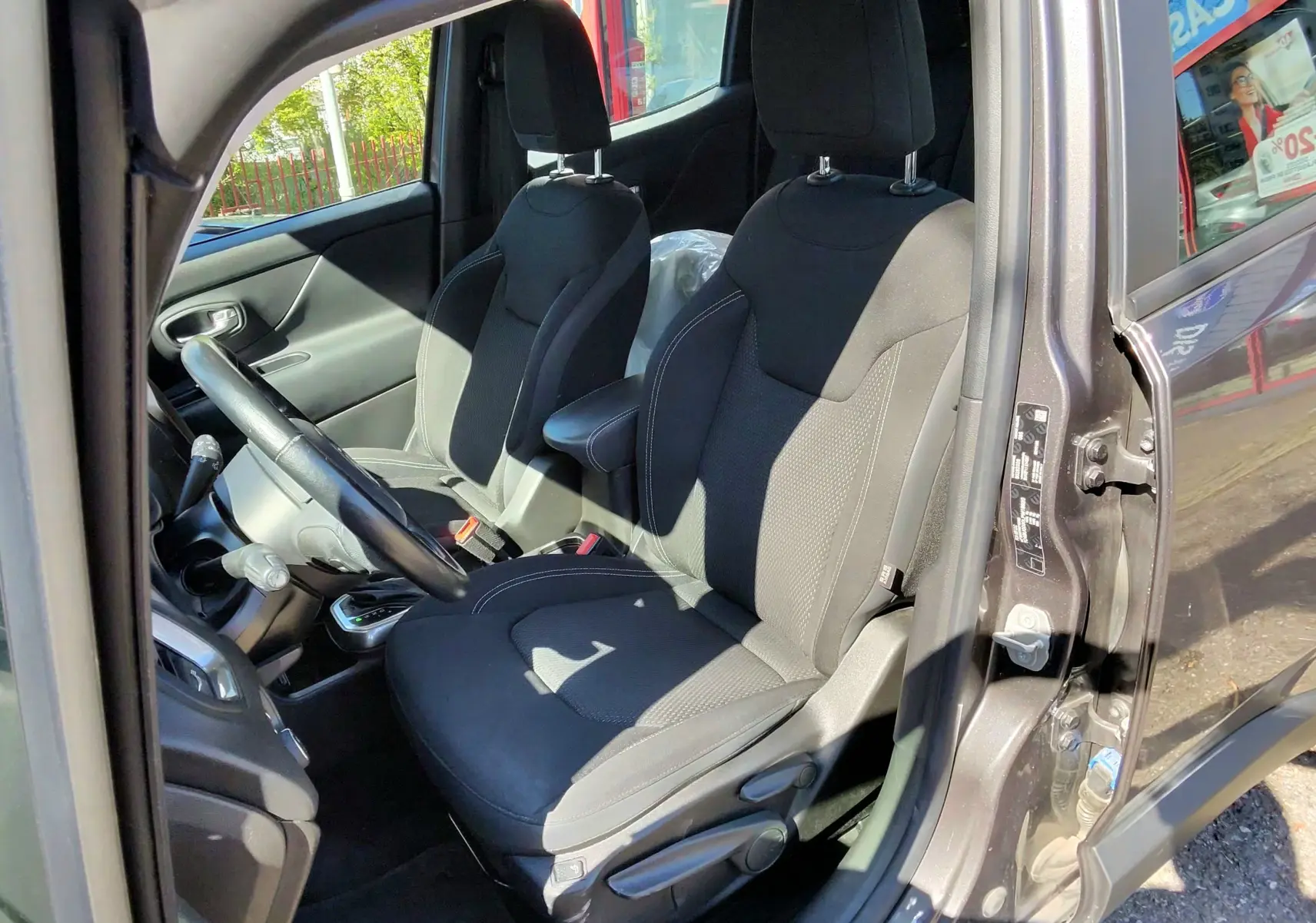 Vue intérieure côté conducteur du Jeep Renegade Granite Crystal 2020, sièges noirs et volant visible.