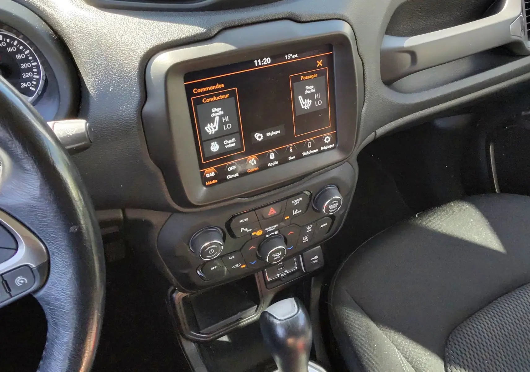 Vue intérieure centrée sur la console centrale et levier de vitesse d'une Jeep Renegade 2020, avec écran tactile allumé.