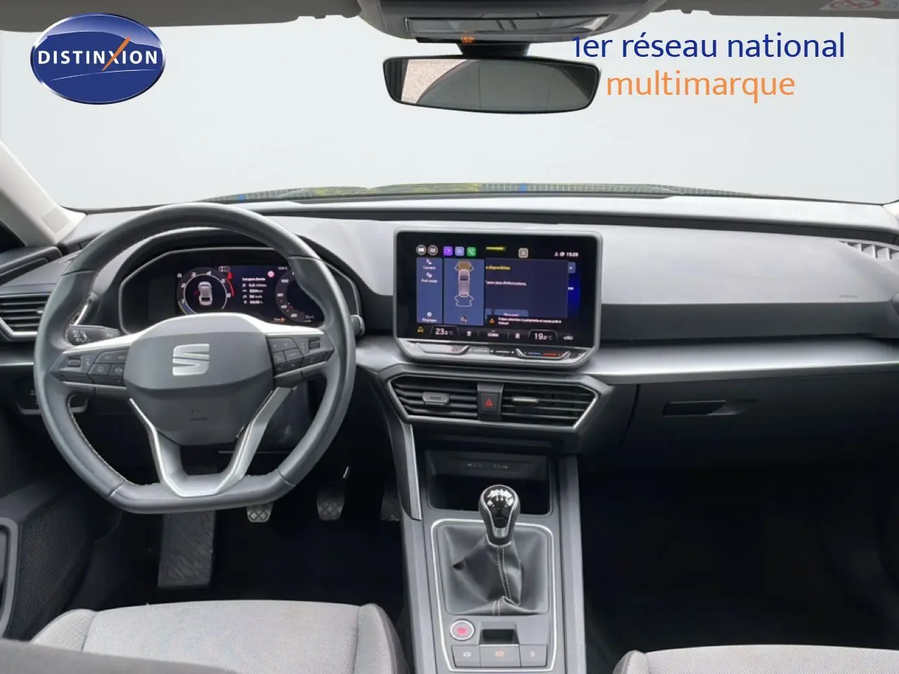 Vue intérieure frontale du tableau de bord et volant de la SEAT LEON ST bleu Fjord avec boîte manuelle et écran tactile central.