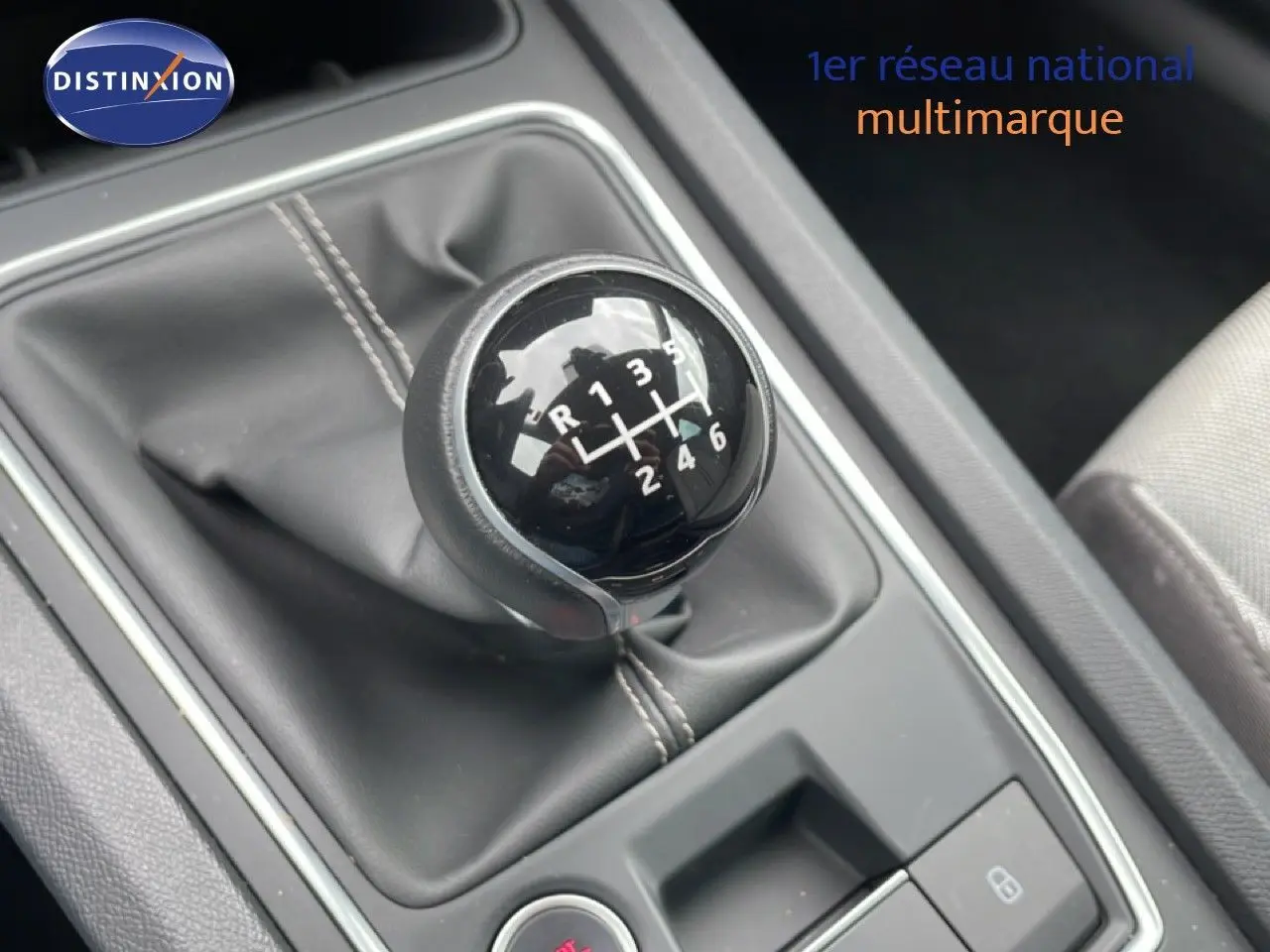 Gros plan sur le levier de vitesses manuel noir de la SEAT LEON ST 2.0 TDI 115CH STYLE XL, intérieur gris et tissu visible.