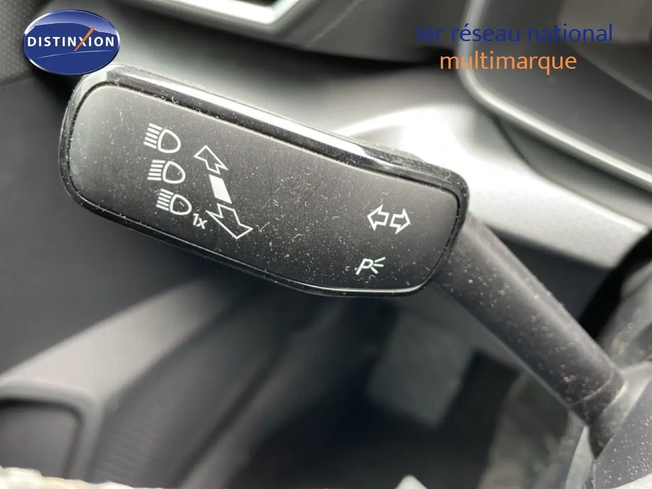 Gros plan sur la commande de clignotants et feux du SEAT LEON ST 2.0 TDI bleu Fjord, intérieur gris-noir.