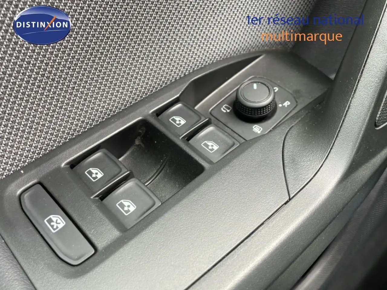 Gros plan sur les commandes de lève-vitres et réglage des rétroviseurs côté conducteur d’une SEAT LEON ST 2025.