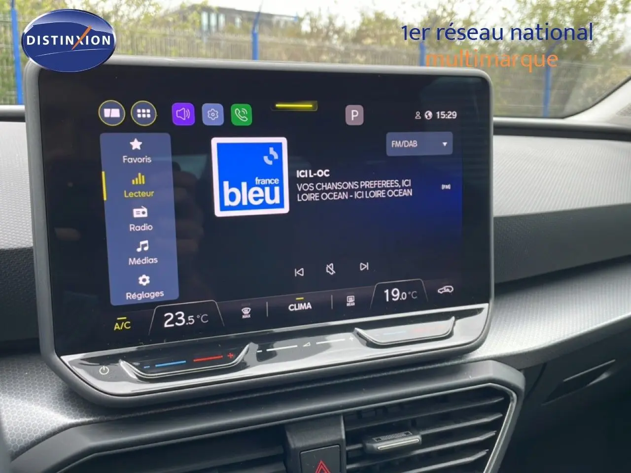 Vue rapprochée de l’écran tactile central du SEAT LEON ST 2025 bleu Fjord avec interface radio et climatisation digitale.