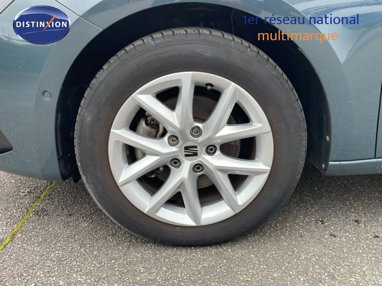 Gros plan sur la roue avant droite d'une SEAT LEON ST bleu Fjord, mettant en valeur la jante alliage argentée.