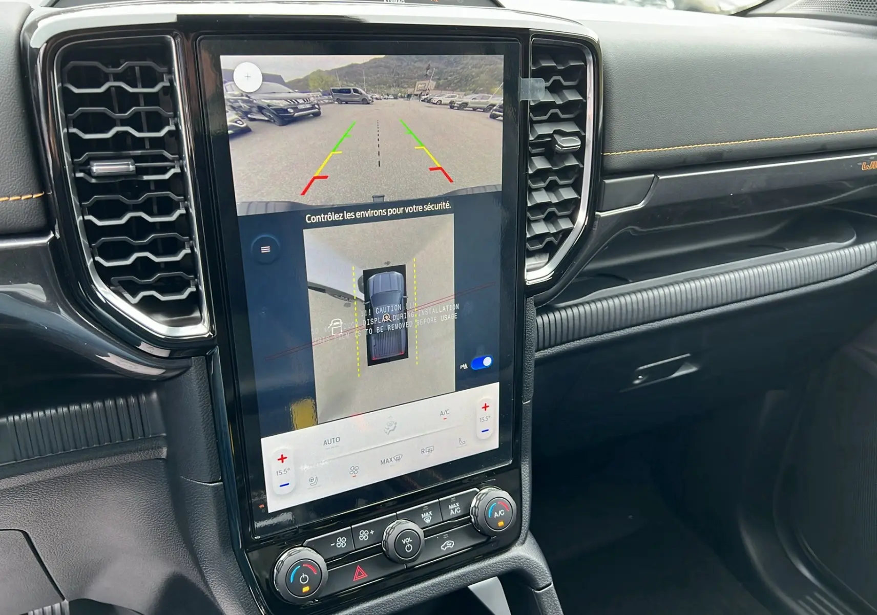 Vue rapprochée de l’écran tactile central du Ford Ranger Wildtrak blanc glacier, affichant la caméra 360° et les commandes climatisation.