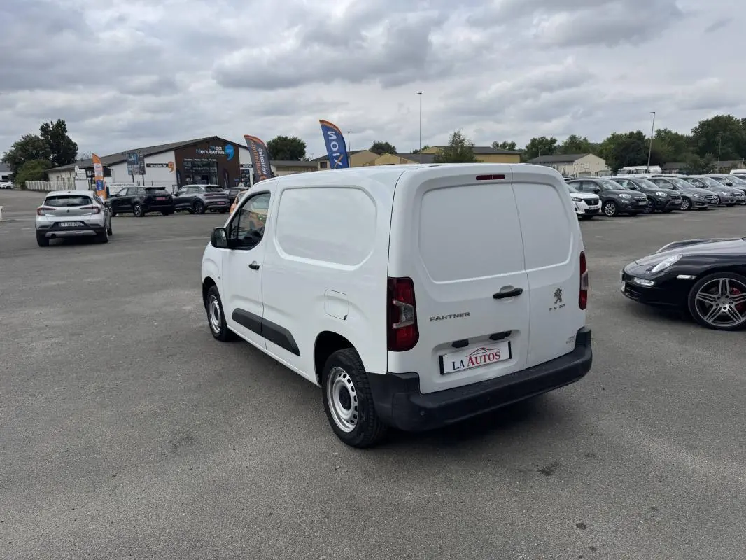 Vue 3/4 arrière droite d’un utilitaire Peugeot Partner blanc 2020 avec portes arrière pleines et pare-chocs noir.