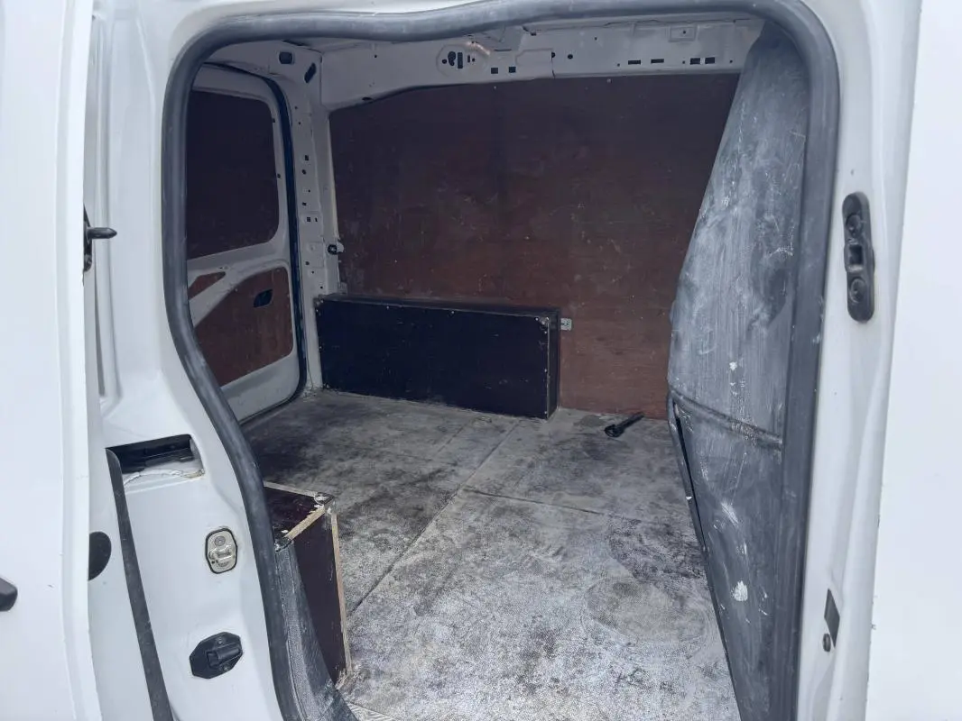 Vue intérieure arrière du Peugeot Partner blanc 2020, montrant l'espace de chargement vide avec parois en bois.