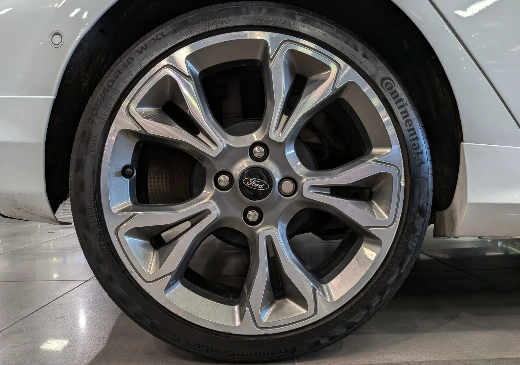 Gros plan sur la roue avant droite d'une Ford Fiesta blanche 2020 avec jante alliage et pneu Continental.