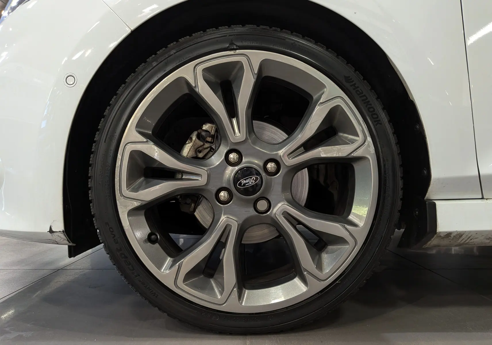Gros plan sur la roue avant droite en alliage de la Ford Fiesta blanche, mettant en valeur le design moderne de la jante.