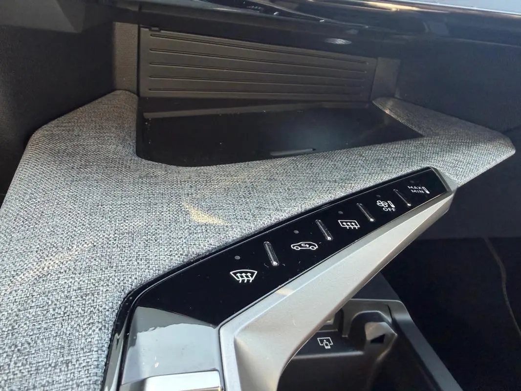 Détail de la console centrale du Peugeot 3008 Hybrid gris 2025, avec commandes tactiles et finition tissu grise.