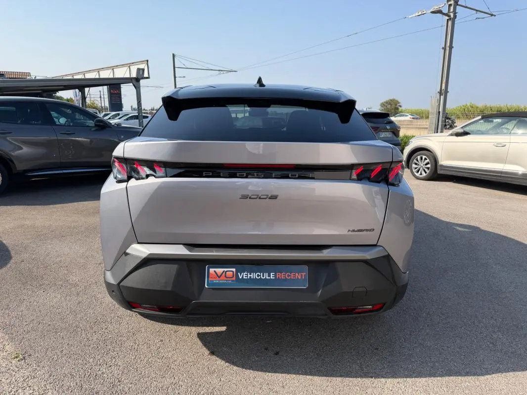 Vue arrière d’un Peugeot 3008 Hybrid gris 2025 avec feux arrière à griffes et toit noir contrasté.