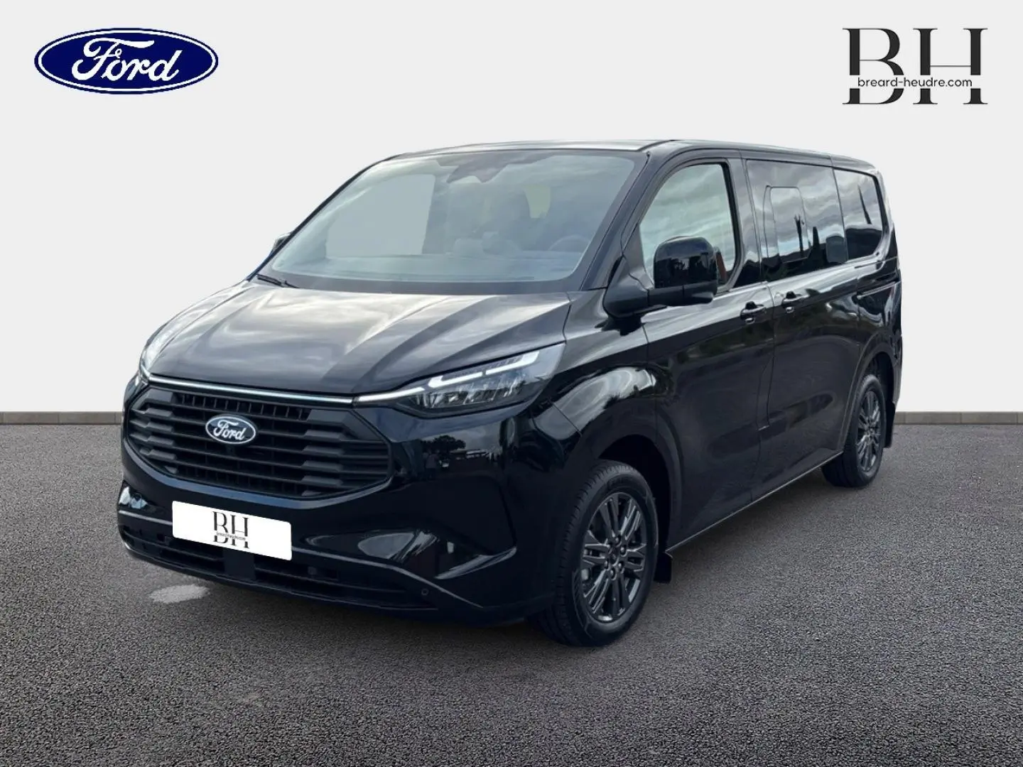 Ford Transit Custom Fourgon noir agate métallisé vu en 3/4 avant droit avec jantes alu gris carbone et vitres surteintées.