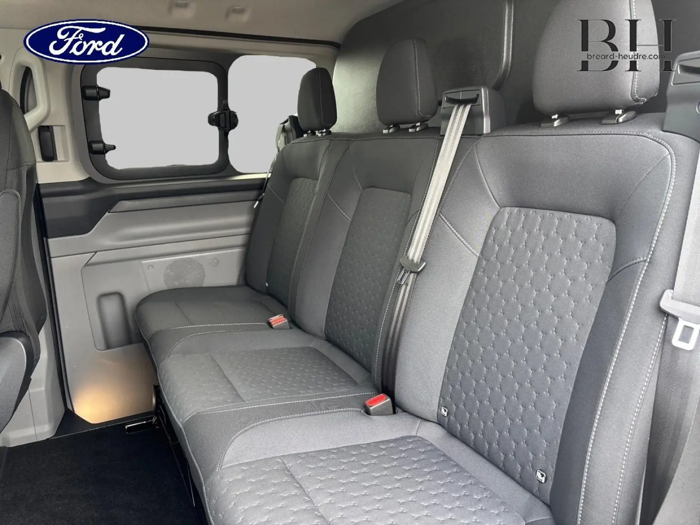 Banquette arrière 3 places en tissu noir dans le Ford Transit Custom Fourgon, vue intérieure côté droit.