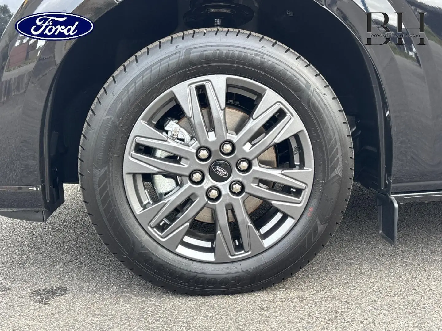 Gros plan sur la roue avant droite du Ford Transit Custom noir Agate Métallisée avec jante alu gris carbone 17 pouces.